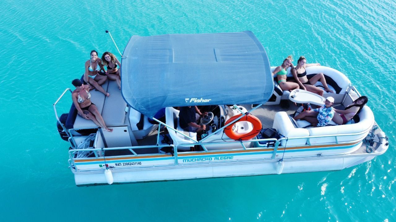 A boat with a covered seating area, life preserver, and a name "MUCHACHO ALEGRE" on the side.