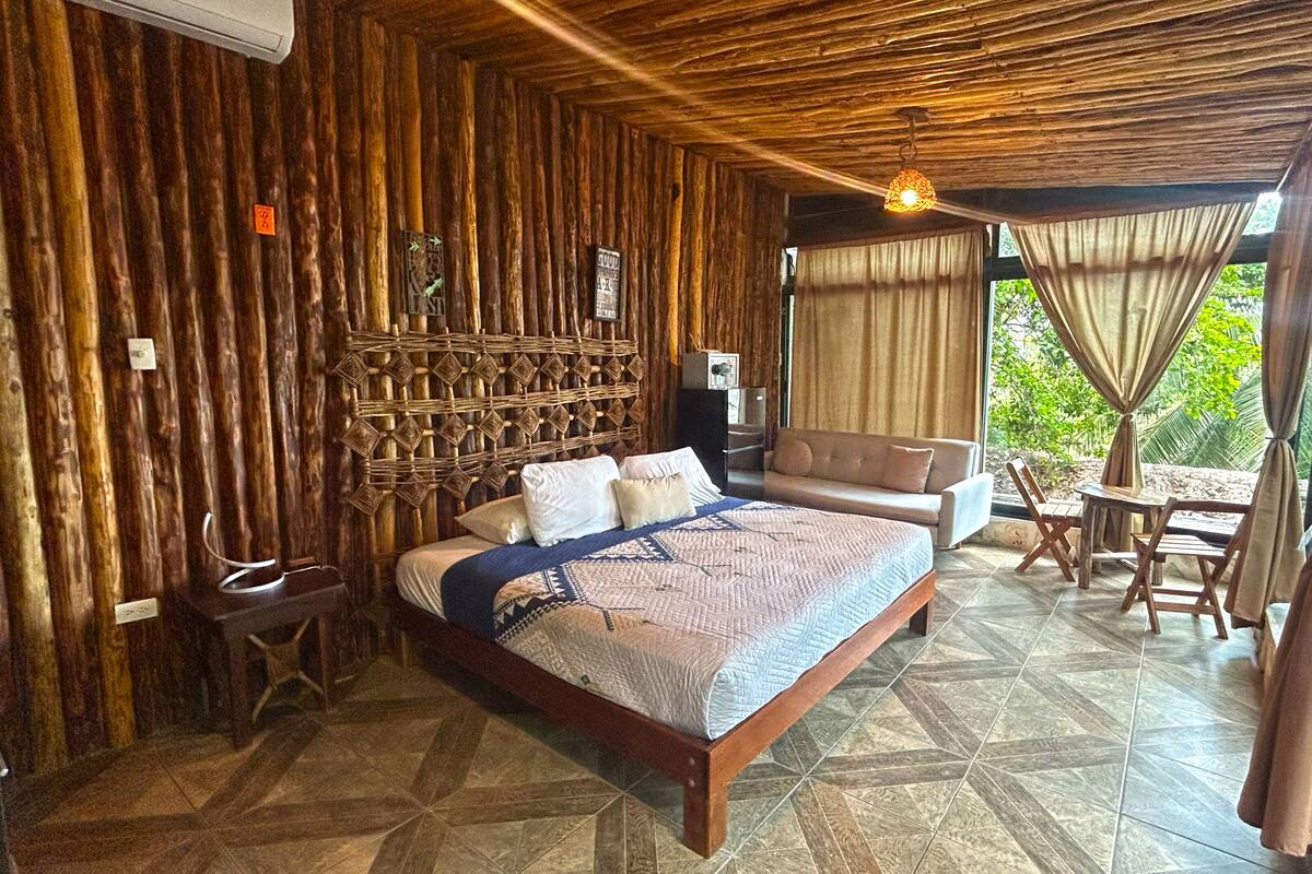 Una habitación con una cama, un sofá, una mesa y sillas.