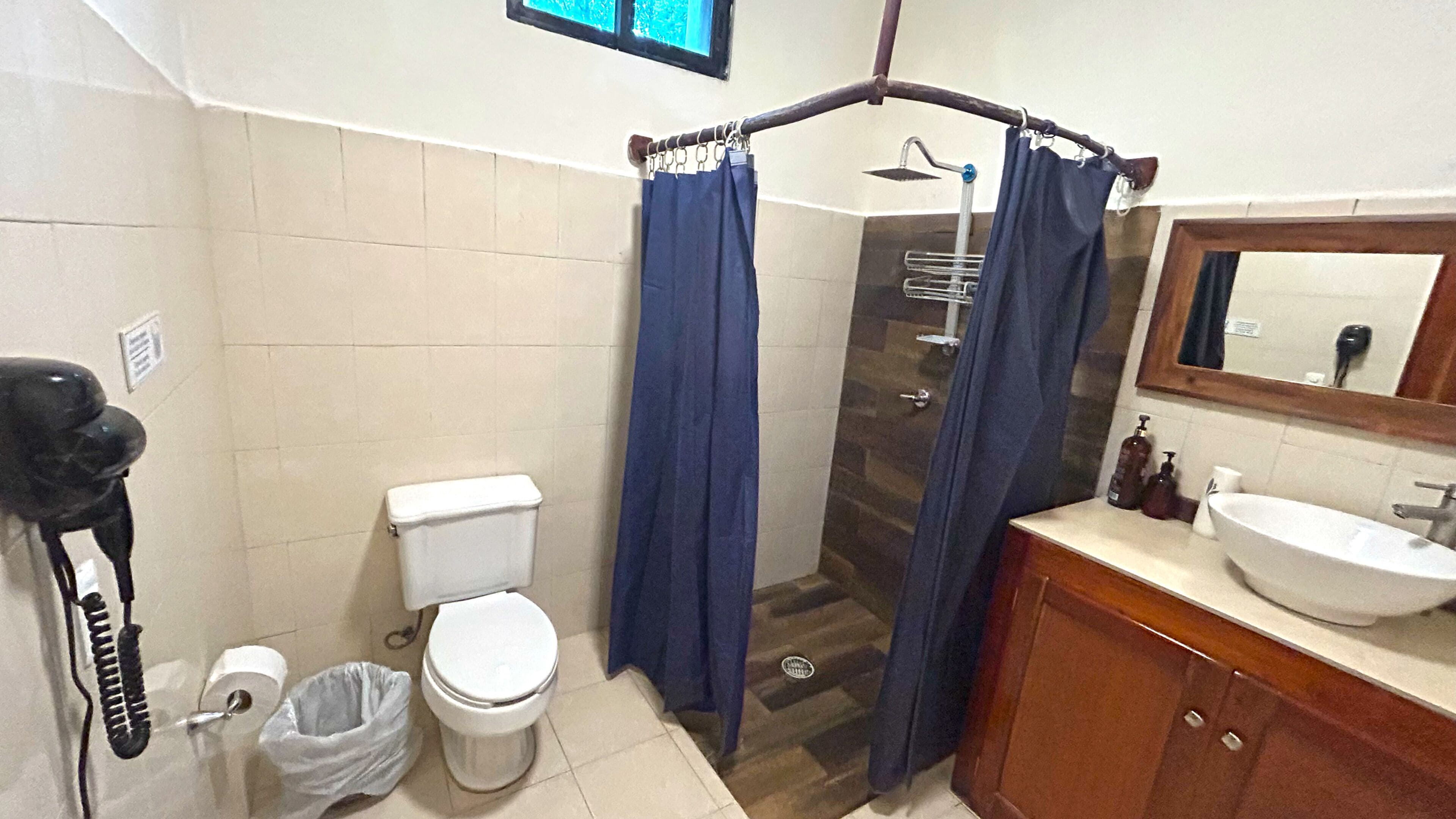Ein Badezimmer mit Toilette, Dusche, Waschbecken und Spiegel.