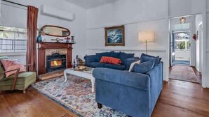 A living room with a fireplace, a sofa, a coffee table, and a rug.