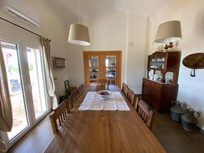 A dining room with a wooden table, chairs, and a buffet cabinet.