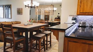 Une cuisine moderne dotée d’un îlot central, de meubles de rangement en bois et d’un coin repas avec un canapé et des chaises.