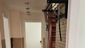En hall med en bänk, en trappa och en dörr längst in.