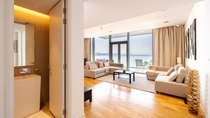 A modern living room with a sofa set, a coffee table, and a view of the city. - DHH Bluewater Island Building 2 Sea View (Dubai)