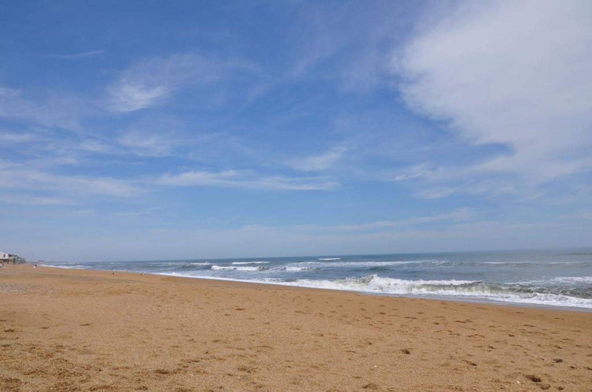 A beach with a clear sky and ocean waves.