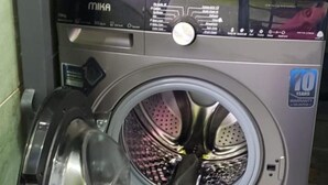A front-loading washing machine with a 10-year warranty sticker. - Stay.Plus Karibu Homes Apartment (Athi River)