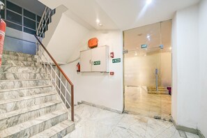 Una escalera con escalones de mármol y barandilla de metal que lleva a una plataforma.