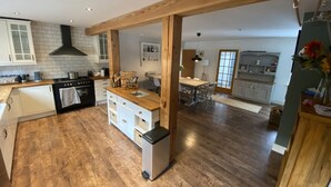 Une cuisine spacieuse dotée d’un plancher en bois, de meubles blancs et d’un îlot central.