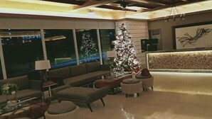 A modern living room with a large Christmas tree, a reception desk, and large windows with city lights visible outside. - Tagaytay Garden View Suites (Tagaytay)