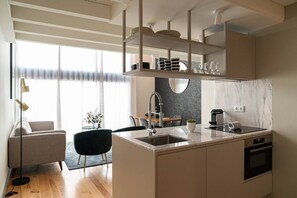 A modern kitchen with a central island, built-in appliances, and a dining area with a table and chairs.