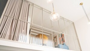 Ein modernes Zimmer mit einem großen Fenster, einer Deckenleuchte und Blick ins Freie.