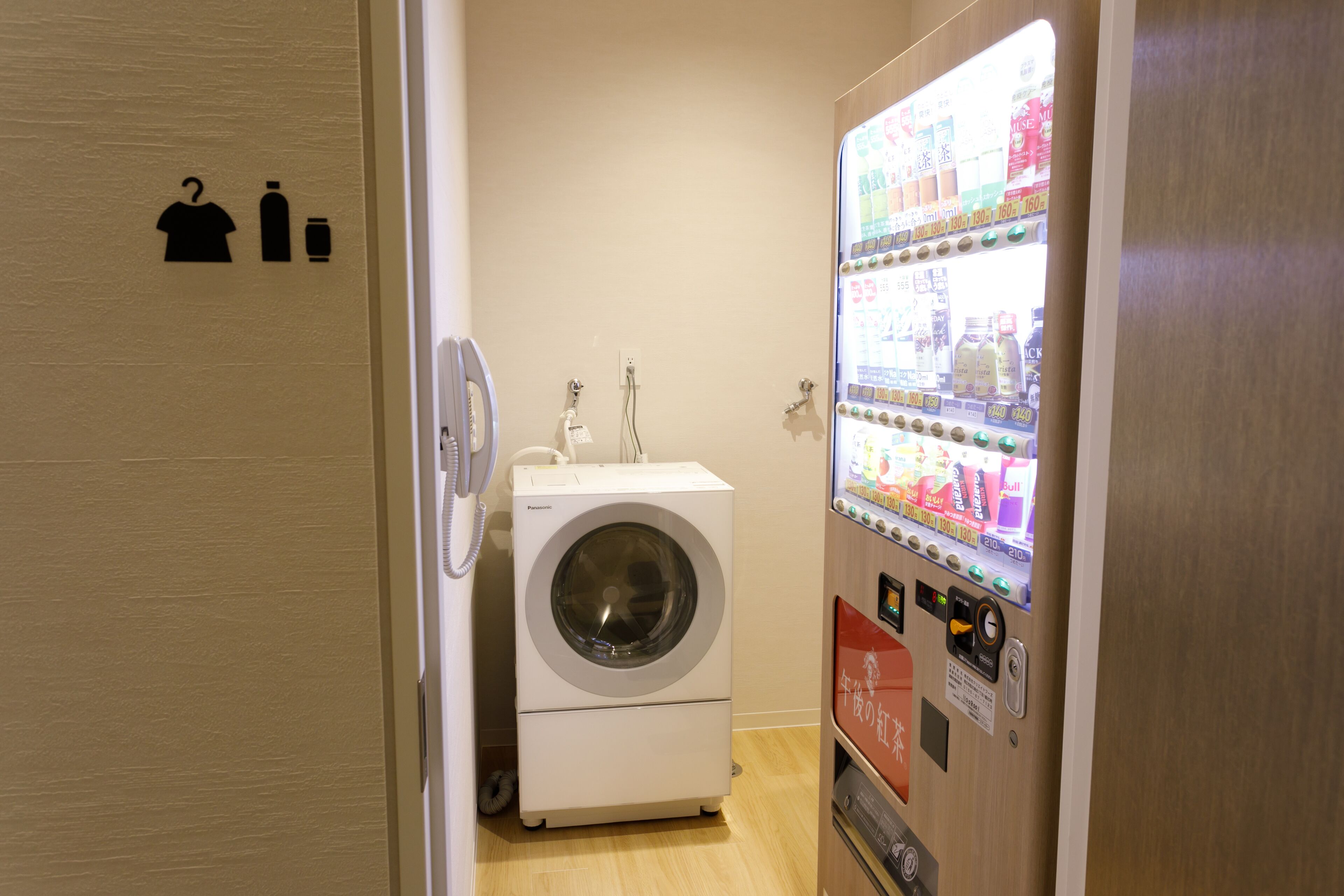 A laundry room with a washing machine and a vending machine.