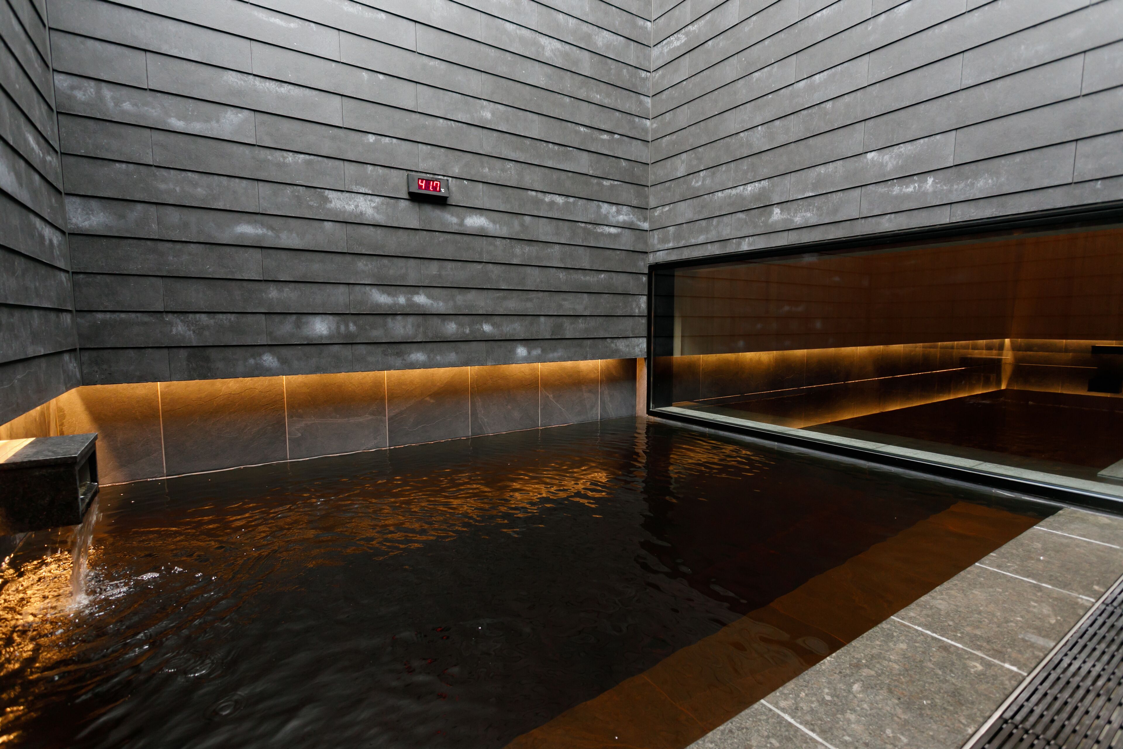 A modern spa area with a large heated pool, a digital clock, and a sleek, contemporary design.