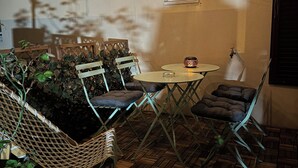 An outdoor patio area with wicker furniture, a small round table, and string lights. - Pleasant townhouse between Paris and Disneyland park (Vaires-sur-Marne)