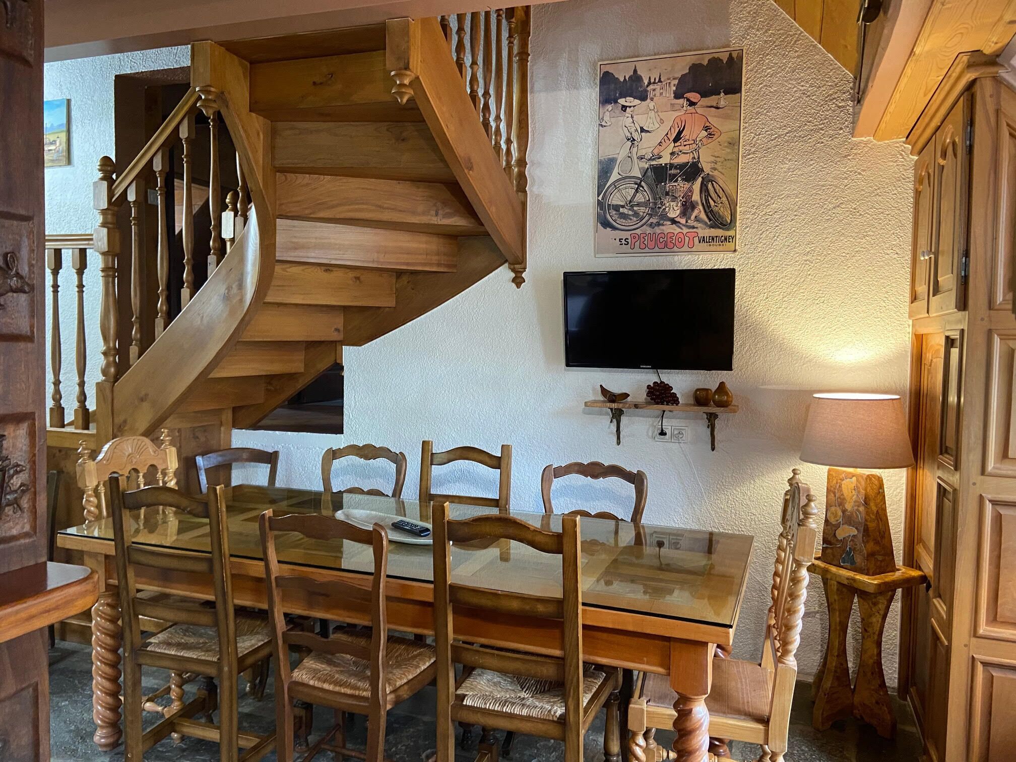 A wooden staircase leading to a dining area with a glass table and chairs.