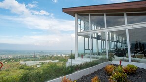 Ein modernes Gebäude mit großen Glasfenstern und Blick auf eine Stadtlandschaft.