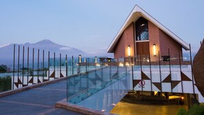 Ein modernes Gebäude mit einem Glaspool und einem Berg im Hintergrund.
