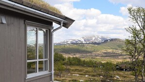 A modern building with a large window overlooking a mountainous landscape with snow-capped peaks. - Awesome home in Rauland with kitchen (Rauland)
