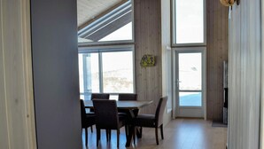 A dining area with a wooden table and chairs, large windows, and a door leading outside. - Awesome home in Rauland with kitchen (Rauland)