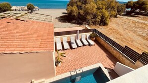Poolområde på taget med udsigt over stranden og havet.