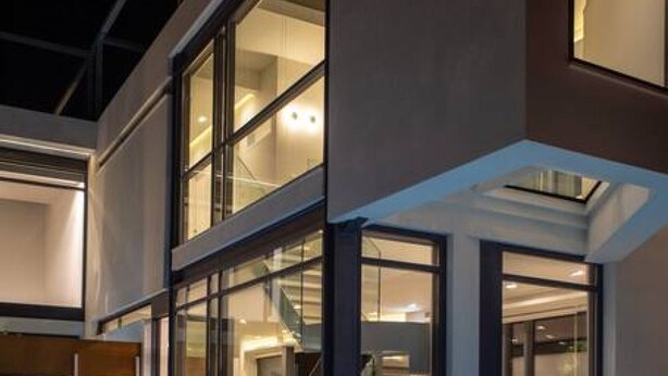 Una casa moderna con piscina, ventanas amplias y un interior bien iluminado.