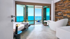 A modern hotel room with a large sliding glass door leading to a balcony with a view of the sea. - Villa Blue Lagoon -Unifying your luxury senses -SEAFRONT (Chania Akrotiri)