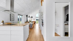 Una cocina moderna con una isla central, suelo de madera y vistas al exterior.