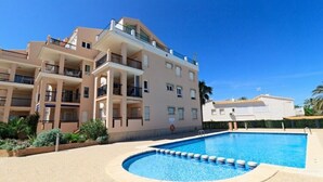 Un hôtel à plusieurs étages doté d’une piscine, de balcons et offrant une vue sur un ciel d’un bleu éclatant.