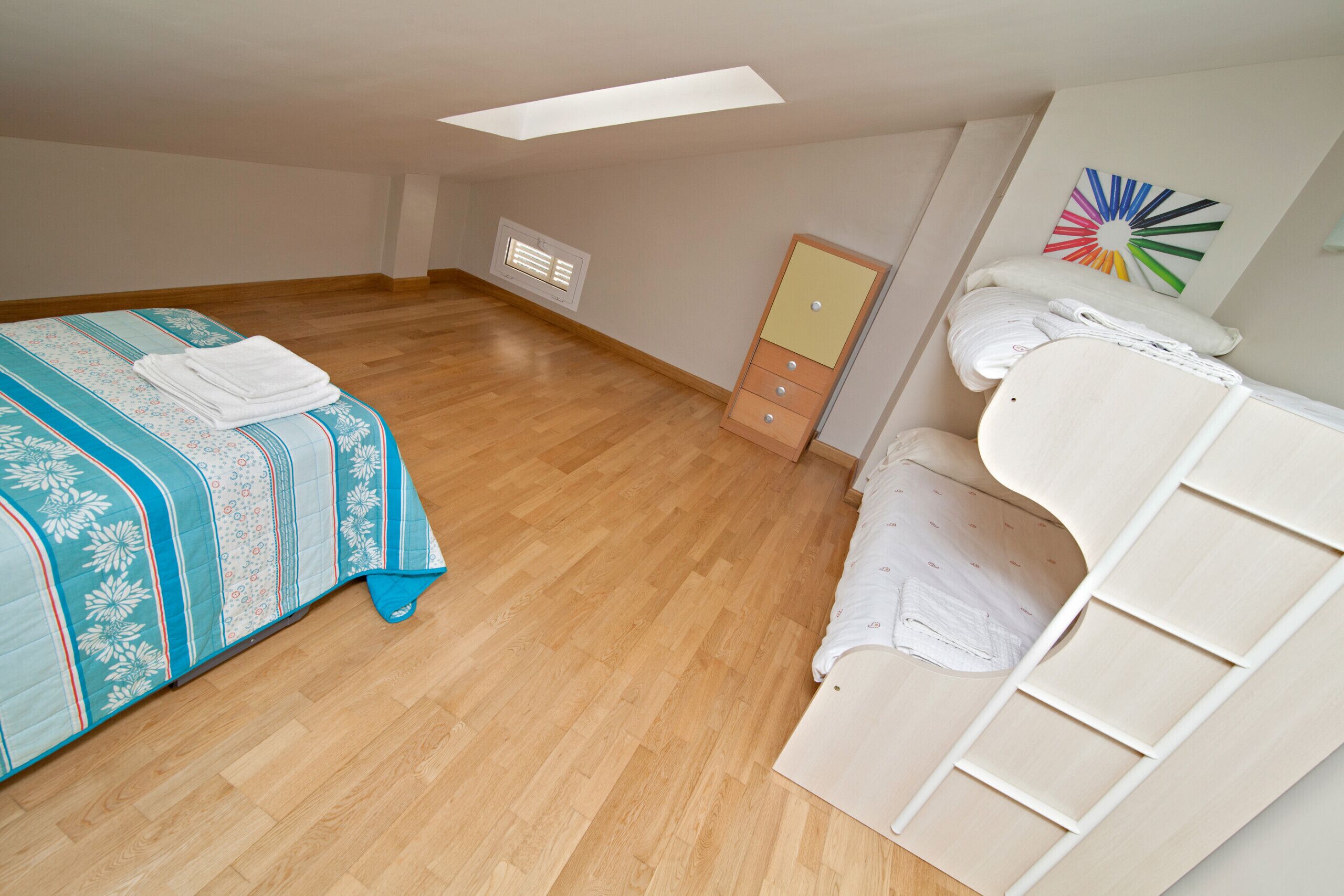 Une chambre à coucher avec un lit, une commode et une armoire.