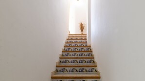 Una scala con piastrelle ornate di blu e giallo che conduce a un pianerottolo.