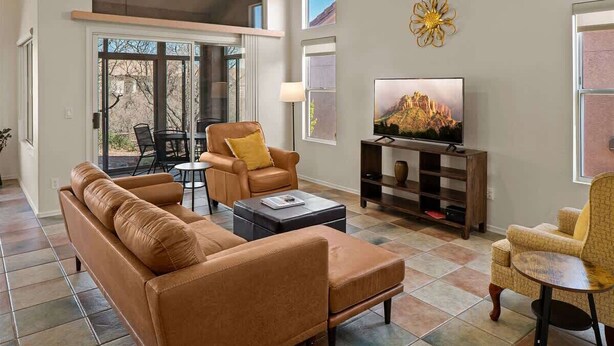 Una sala de estar con sof á, sillón, mesa de centro, televisor y estantería.