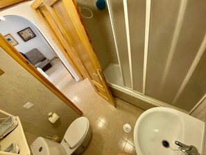 Een badkamer met toilet, wastafel en douche.
