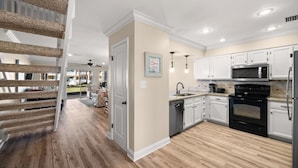 A modern kitchen with white cabinets, a black stove, and a microwave. - 4C, Meet Me at The Gulf (Miramar Beach)