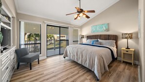 A bedroom with a bed, a ceiling fan, a nightstand, a chair, and a view of the outside. - 4C, Meet Me at The Gulf (Miramar Beach)