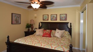 A bedroom with a bed, a ceiling fan, and three framed artworks on the wall. - 7G, Emerald Escape (Destin)