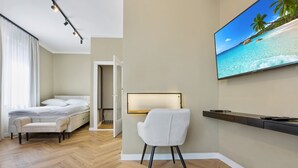 Une chambre à coucher moderne avec un lit, une chaise, un téléviseur et une étagère fixée au mur.