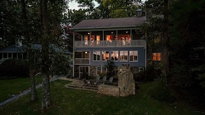 A two-story house with a balcony, stone foundation, and a stone fireplace. - A Lake Blue Ridge Cottage | Morganton, GA (Morgantown)