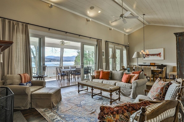 A spacious living room with a large window, a ceiling fan, and a view of the outdoors.
