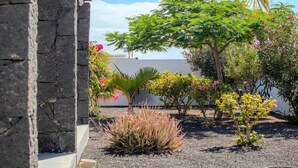 A garden with various plants and a stone wall. - Villa Fedelian 1 with garden and heated pool (Playa Blanca)