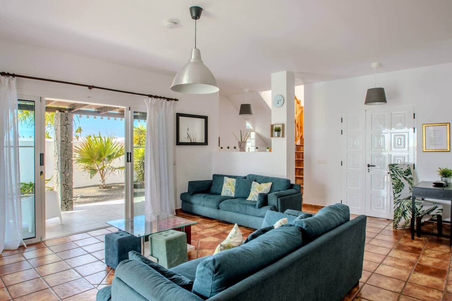 Un salon moderne comprenant un ensemble de canapés, une table basse en verre et un coin repas avec une chaise et une table.