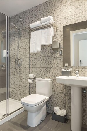 A bathroom with a shower, toilet, sink, and a glass-enclosed shower area. - Apartamentos Martalia Arenal (Ronda)