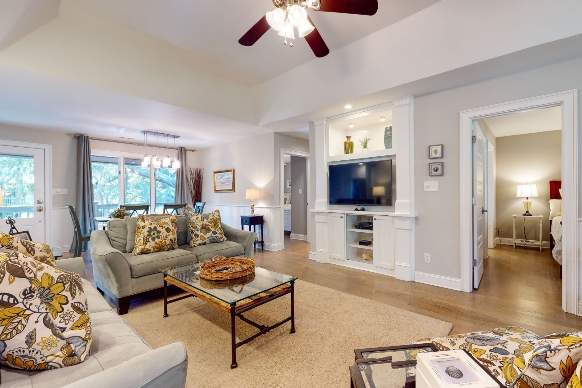 A spacious living room with a sofa, coffee table, and a television.