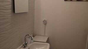 Un baño con lavabo, espejo y barra para toallas.