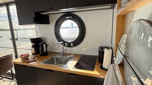 Una cucina moderna con un'ampia finestra, un lavandino, una macchina da caffè e un portasciugamani.