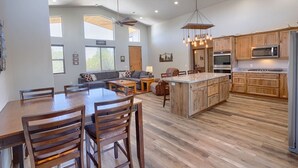 A spacious kitchen with wooden cabinets, a central island, and modern appliances. - Gorgeous Lazy Bear Inn (Show Low)