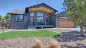 A modern two-story house with a covered porch, a well-maintained lawn, and a garage. - Gorgeous Lazy Bear Inn (Show Low)