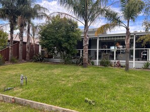 Stroll through the serene surroundings of this two-story home, featuring a covered patio and beautifully manicured lawn.