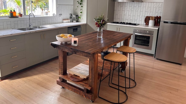 A modern kitchen with a wooden island, bar stools, a built-in oven, and a stainless steel refrigerator. - Leisure escape (Rosebud)
