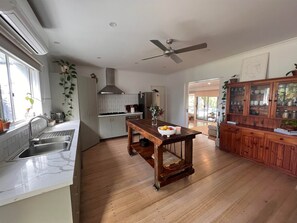 Enjoy cooking in this well-equipped kitchen with a central island, sink, and stainless steel range hood.