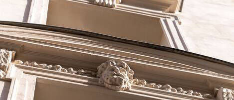 Primer plano de detalles arquitectónicos de un edificio, con tallas ornamentales y diseño clásico.